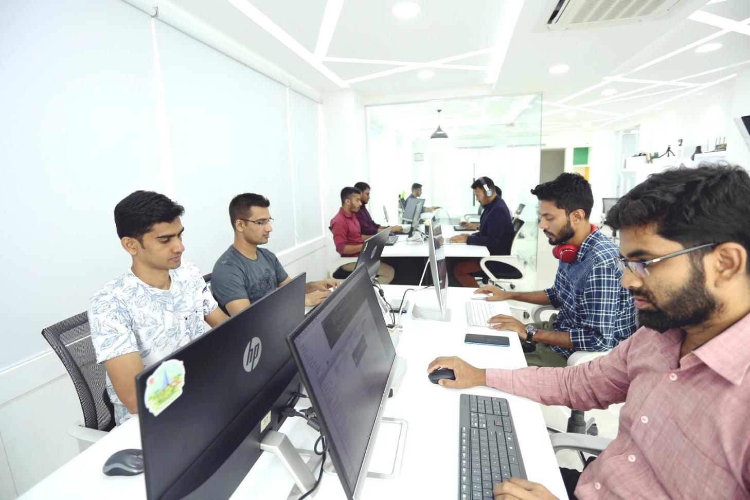 Instructor reviewing blockchain code with students during hands-on lab session